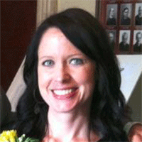 Headshot of a dark-haired businesswoman smiling
